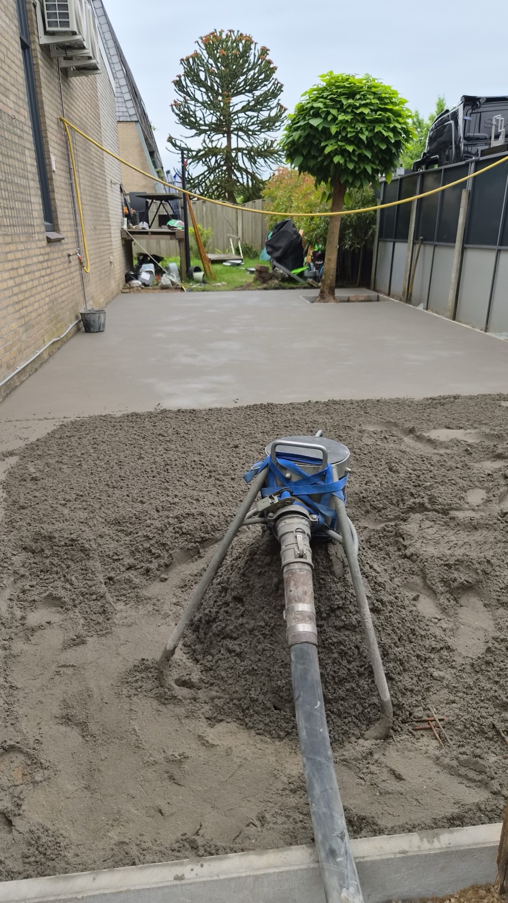 Zand-cement met pompslang naast een vers gestorte buitenstrook