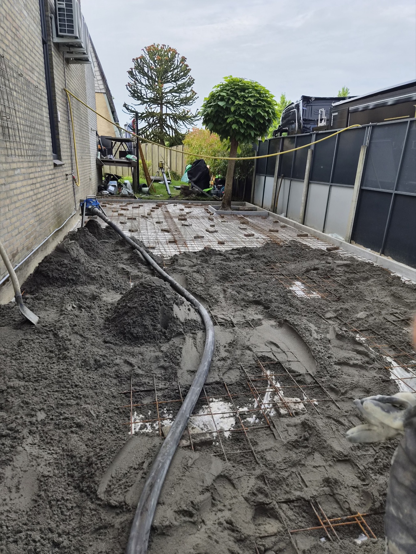 Zand-cement wordt verdeeld over een wapeningsnet
