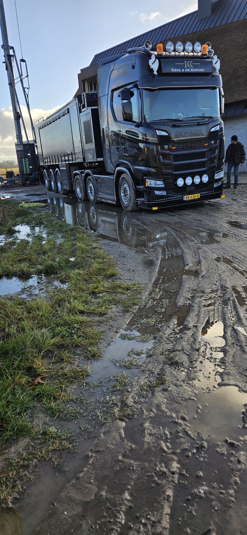 Zwarte vrachtwagen met kipper op een modderige bouwplaats